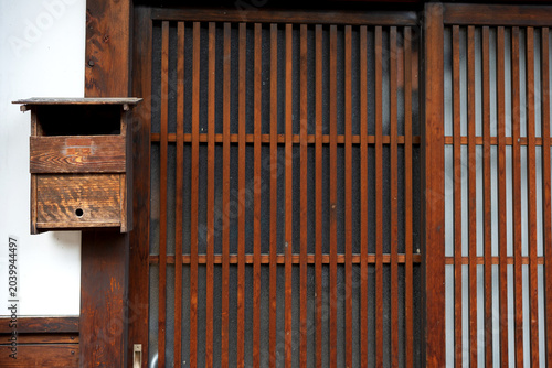 Traditional Japanese Wooden Mailbox Mounted Next to a Slidings Lattice Door