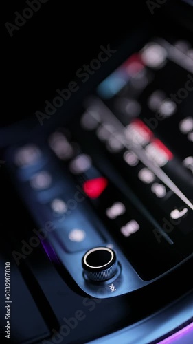 Vertical format video of Car dashboard volume knob. Driver's hand adjusts volume control of car radio. Male hand control radio or music in car in motion. Turns up the volume of the music in the car.