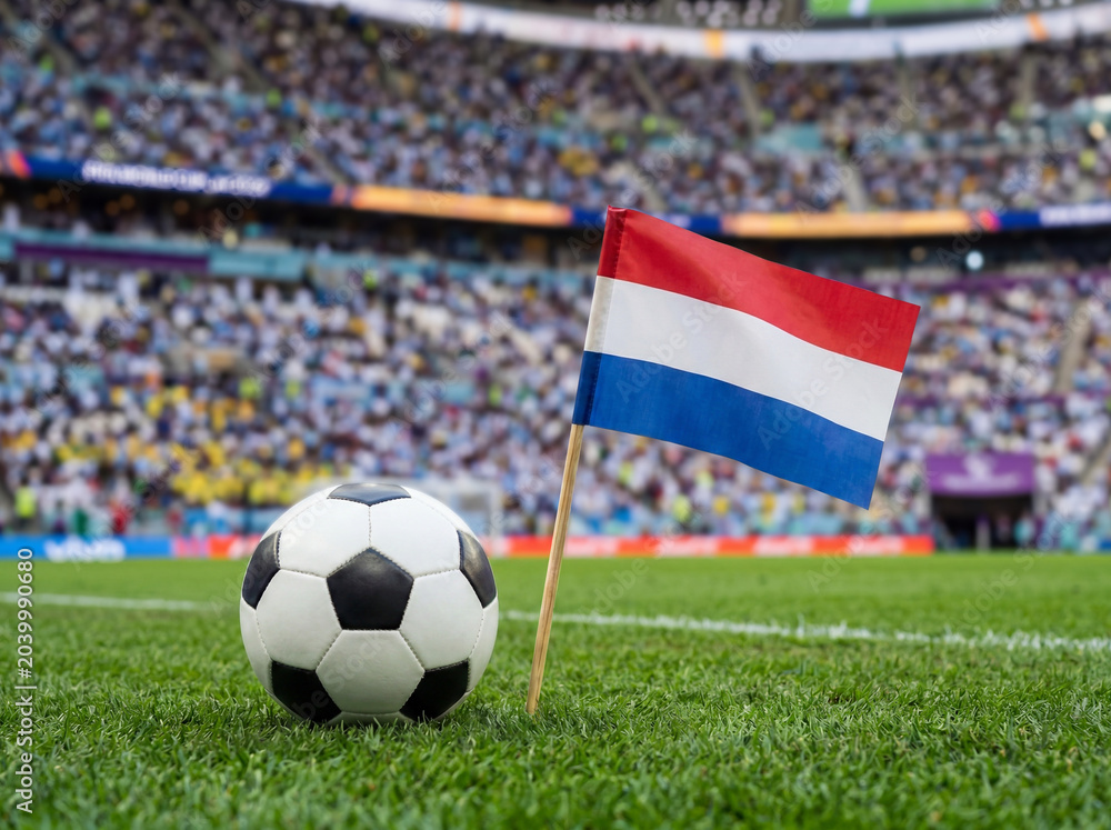 Fototapeta premium Dutch flag and football on green field in stadium