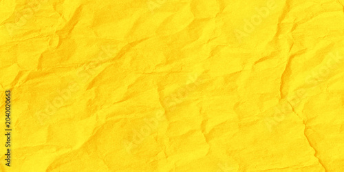 Obraz na plátně Vibrant yellow crumpled paper texture background with deep wrinkles and creases