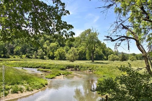 Beautiful landscape of a small stream in a lush green valley on a spring morning in Dubuque County, Iowa.