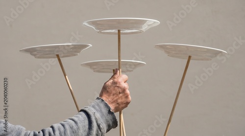Multitasking Concept, Hand Spinning Plates on Wooden Sticks