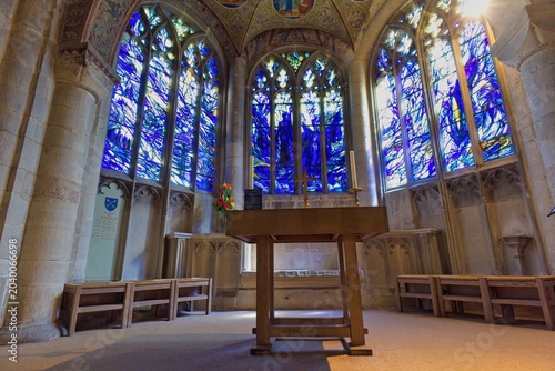 Obraz na plátně A serene Cathedral interior bathed in blue light from large, vibrant stained-glass windows
