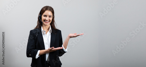Attractive business woman in suits and headsets are smiling while working isolate on white background. Customer service assistant working in office. VOIP Helpdesk headset