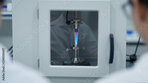 Detailed view of a blue flame combustion test in a laboratory chamber. Scientists conduct a scientific experiment for chemical research and industrial quality control