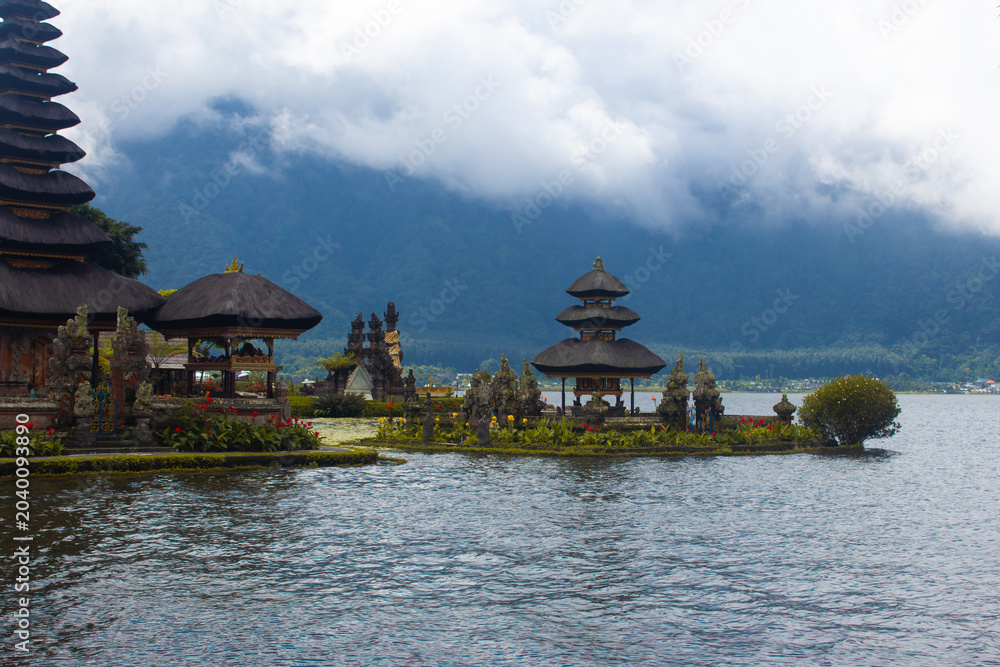 Obraz premium Ulun Danu Beratan Temple floating on Lake Beratan in Bali, Indonesia, with misty mountain backdrop.