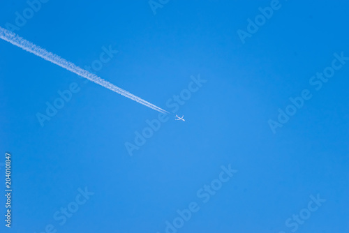 Airplane streaking across the blue sky