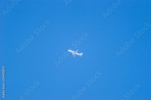Airplane streaking across the blue sky