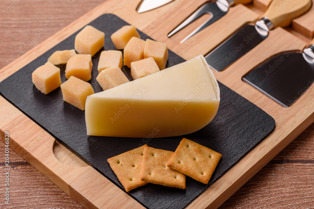 Fototapeta premium Aged cheese in a triangular block with jam, figs, and nuts. Aged cheese