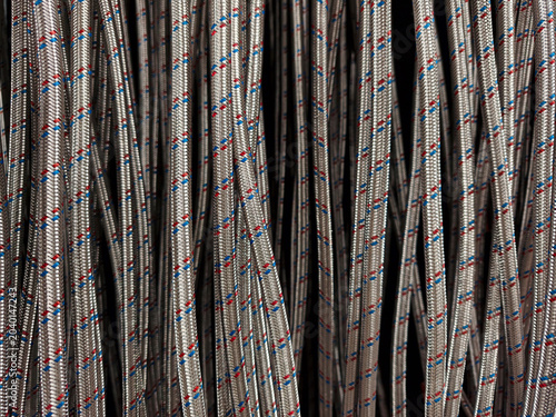 Fotografija Braided water hoses for plumbing systems hanging on supermarket hooks in constru