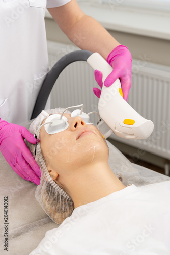 woman receiving facial treatment with device