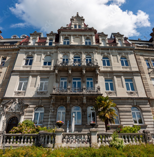 Full view of a grand historic villa on Seestrasse with ornate balconies and a small palm tree in the garden, located on the Lake Constance embankment