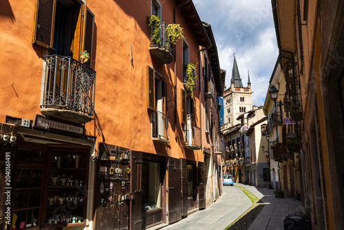 Tablou pe pânză Campanile of the San Giusto Cathedral in Susa seen through an alleyway in the hi