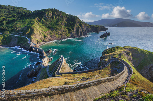 Bild auf Leinwand Winding Stone Staircase Leading Down to a Dramatic Coastal Bay with Turquoise Wa
