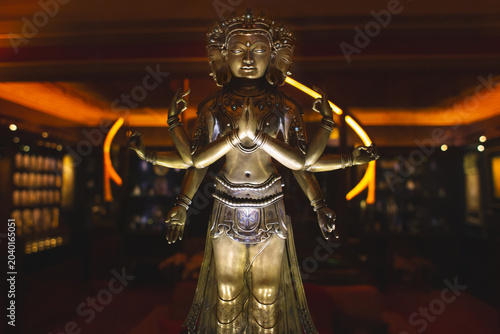 Foto Golden statue of Avalokiteshvara or a multi-armed deity in a museum