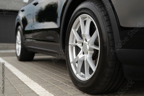 Photos Close-up of a silver multi-spoke alloy wheel on a black luxury SUV
