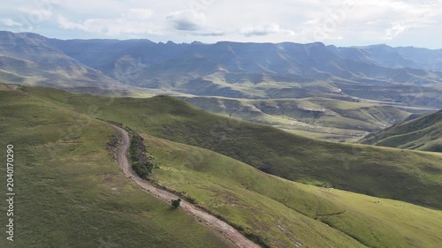 Aerial Ridgeline With Dirt Track Winding Toward Distant Drakensberg Peaks, Offroad Expedition Navigates Rugged