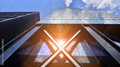 Steel and glass. The subject of modern architecture or construction industry. Modern office building facade with tall steel construction elements and full height windows between.
