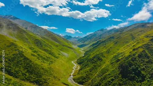 dolly backwards drone hyperlapse in green mountains of Kyrgyzstan at sunny summer day