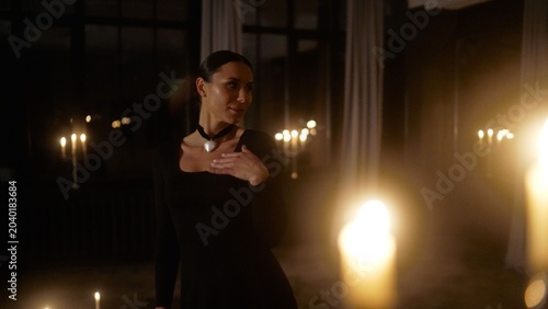Photos Woman in black dress with pearl necklace standing in candlelit room