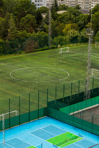 Принти на полотні Aerial view of outdoor sports complex with green artificial football field, goal