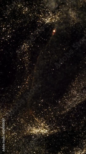 Vertical Golden Glitter Shower 4K Loop features golden glitter  particles swirling around and criss-crossing in a black atmosphere in a vertical ratio loop.