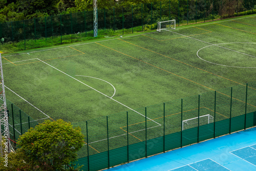 Photos Elevated side view of green artificial football field with white and yellow mark