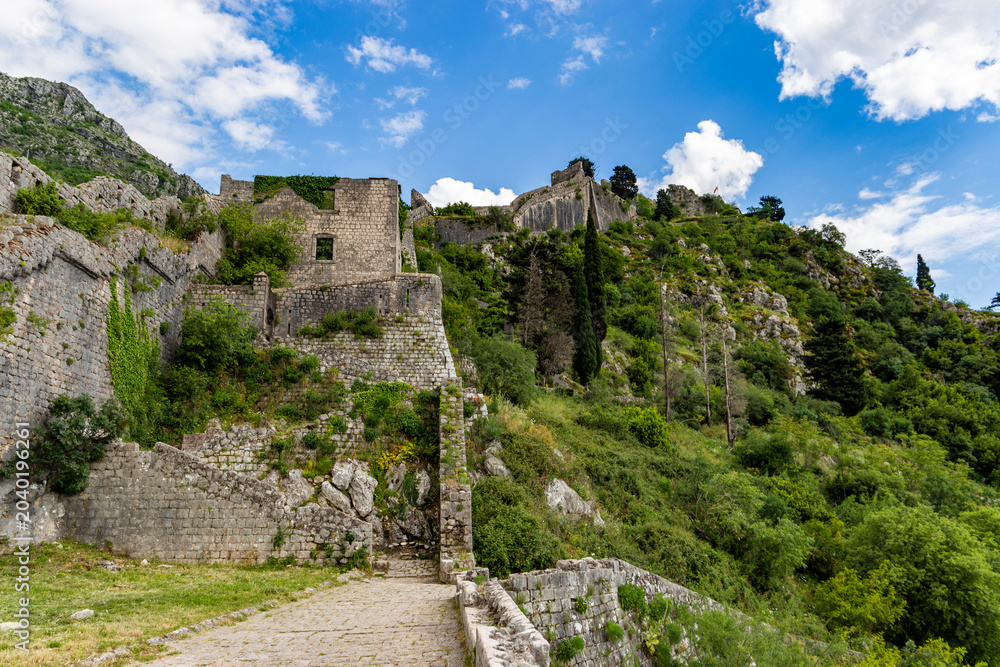 Fototapeta premium Rugged serpentine stone trail winding high up the cliffs towards the historic St John Fortress in Kotor
