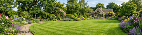 panoramic view of a garden with lawn and flower beds