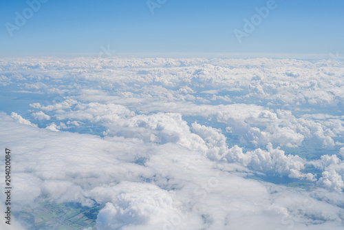 Billede på lærred Aerial view of cumulus clouds above land and horizon