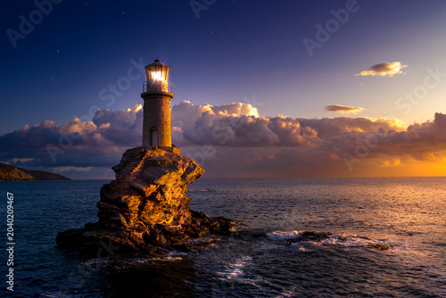 The beautiful Lighthouse Tourlitis of Chora at night. Andros island, Cyclades, Greece