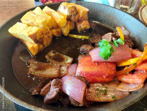 Fotografi Lomo Saltado o salteado, plato típico de la gastronomía peruana, en base a lomo