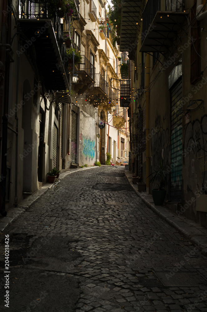 Fototapeta premium Cobblestone Street Under Glowing Lights