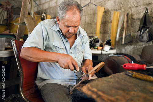 Foto Artisan man sharpening tool in workshop