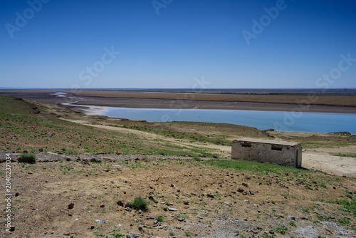 Amudarja or Amu Darya River, the Border between Uzbekistan and Turkmenistan with a Dilapidated Building on the Uzbek Side