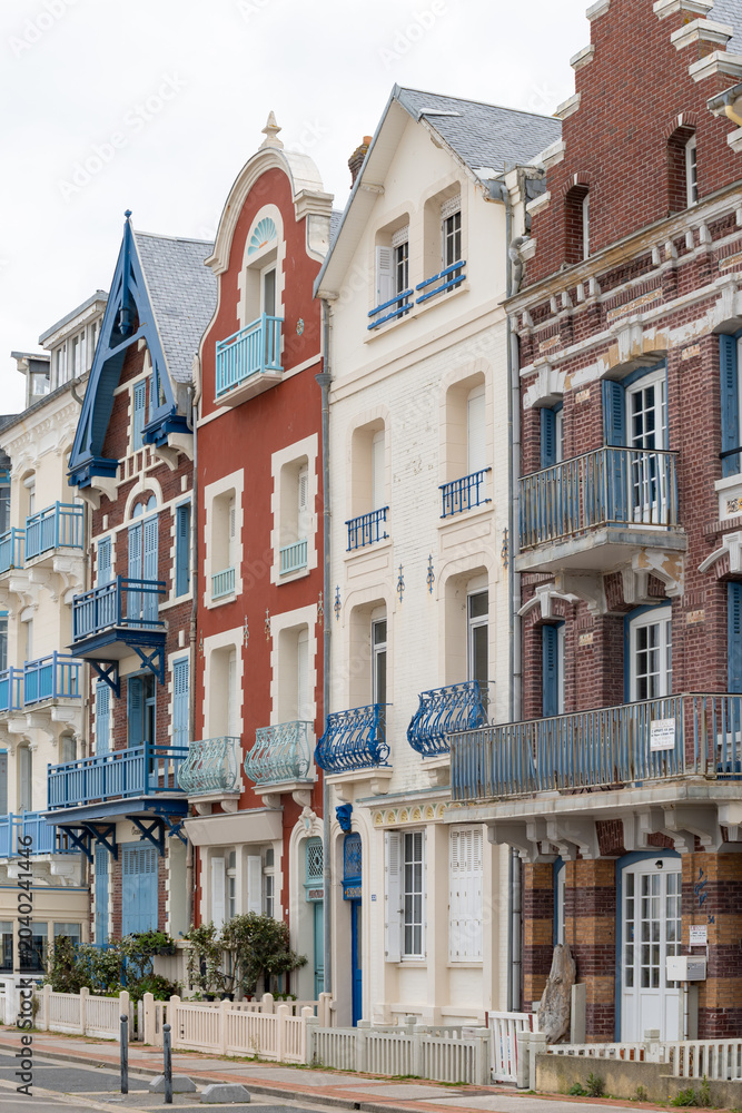 Obraz premium Houses of Mers-les-Bains, seaside town with 19th-century sea-bathing villas with colorful wooden balconies and white chalk cliffs, tourists destination in France