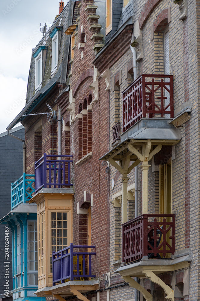 Obraz premium Houses of Mers-les-Bains, seaside town with 19th-century sea-bathing villas with colorful wooden balconies and white chalk cliffs, tourists destination in France