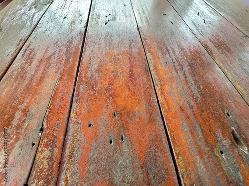 Close-up of weathered old wooden floor planks showing natural grain, aged texture, and vintage nails, perfect for rustic or grunge background design.