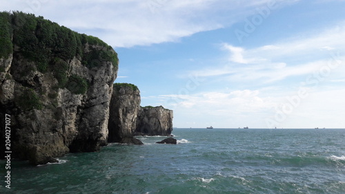 Obraz na plátně Scenic coastal cliffs overlooking the ocean with ships on the horizon