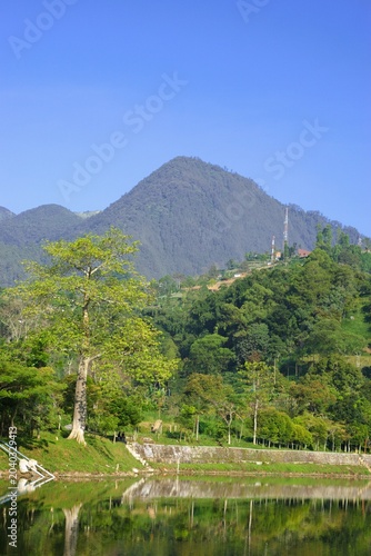 scenic mountain landscape reflected in a calm lake with clear blue sky