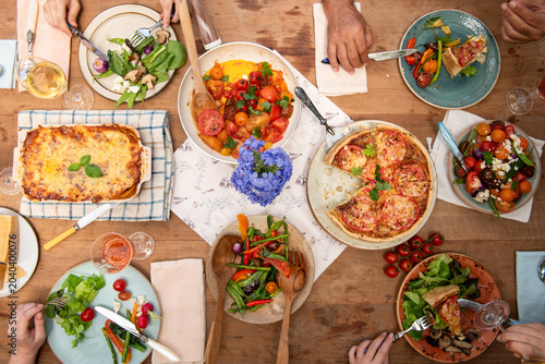 Fotografia Aerial view of a diverse group enjoying a colorful meal at a wooden table