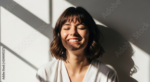 Radiant young woman with short hair enjoying sunlight expressing joy and positive emotions natural light portrait