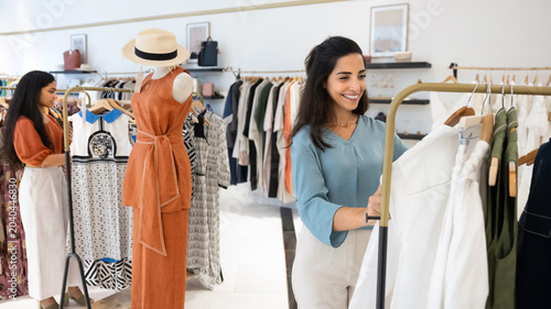 Foto Two stylish women happily enjoy shopping experience, browsing fashionable clothe
