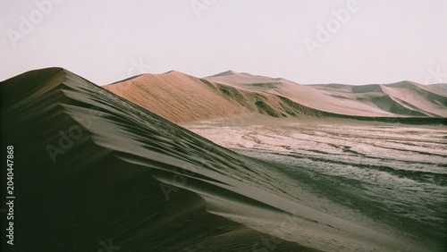 Quadro em tela Dramatic, towering dunes of deep orange and red, with shadows creating dynamic patterns