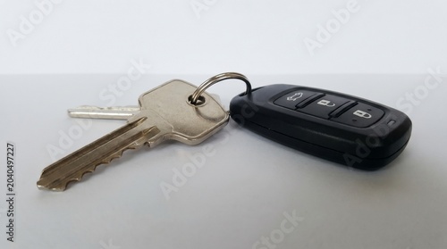 House and car keys hanging together on white isolated background minimalist concept