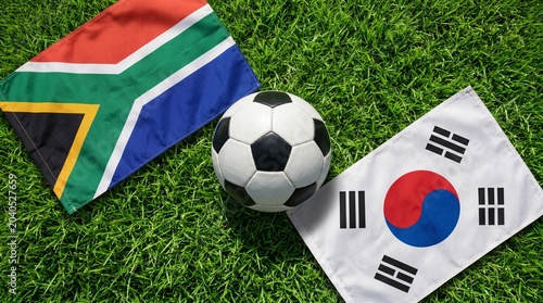 soccer ball resting on a lush green field, flanked by the national flags of South Africa and South Korea