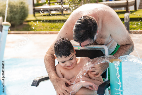 Father and son enjoying splash play in water park