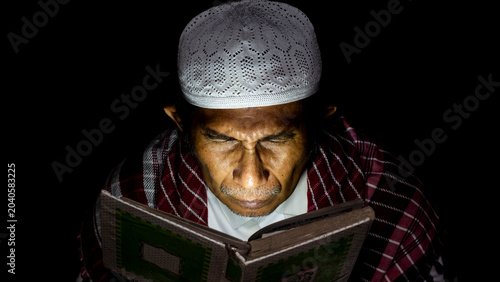 Tableau sur toile a muslim man is reading the quran at night