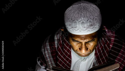 Tableau sur toile a muslim man is reading the quran at night