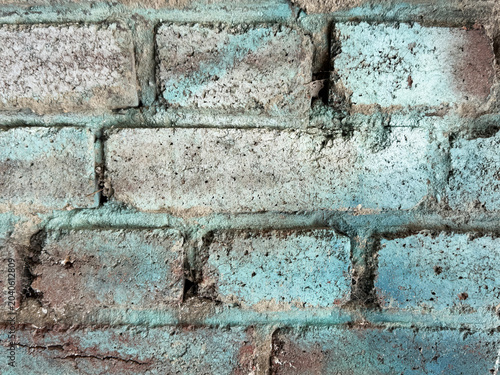 Verwitterte Ziegelmauer mit weiß-blauer Oberfläche